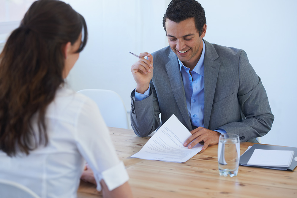 man smiling and looking at a resume